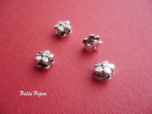 Distantier din 2 floricele cu 5 petale prinse pe un tub aprox 6x8 mm