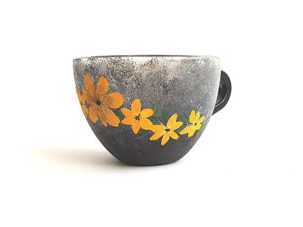 Ceasca de  cafea cu flori presate galbene.