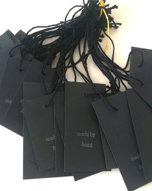 Price tags. Etichete negre cu mesajul Made by hand.