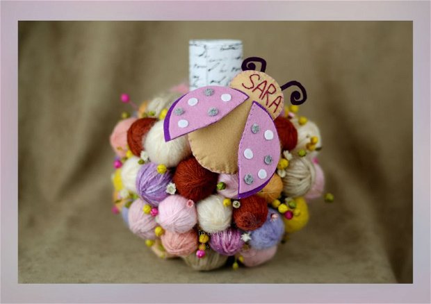 Aranjament pentru lumanarea de botez, decorat cu gheme, flori uscate si jucarie din fetru personalizata.