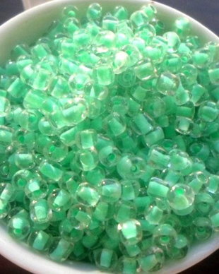 Margele nisip alb transparent cu miez verde 4 mm 100 g.