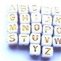 Margele acrilice cub alfabet alb cu litere auriu 33 buc. 5 mm