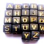 Margele acrilice cub alfabet negre cu litere aurii 34 buc. 6 mm
