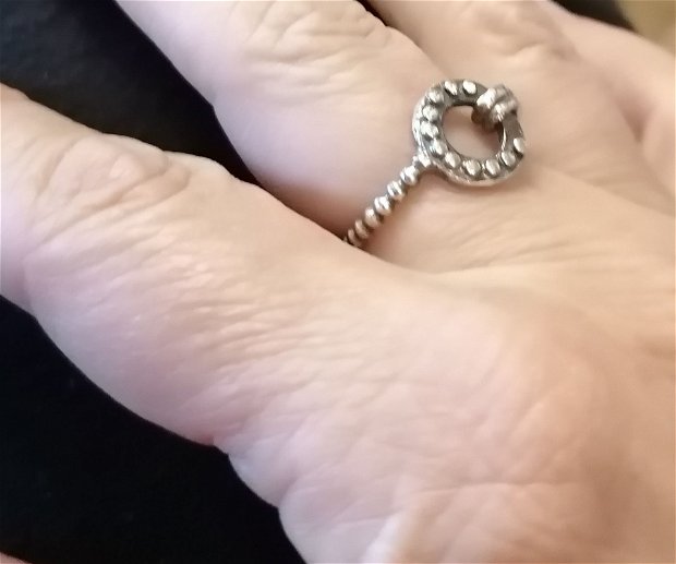 Inel de autor din argint fin, asimetric, în forma de nod prins de un cerc decorat cu margele de argint, cu banda din margele de argint
