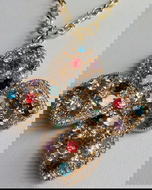 Colier cu o baza lucrata din ata cu margele de nisip cu o prelungire de lantisor si un pandantiv metalic floare batut cu cristale multicolore