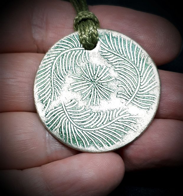 Pandantiv circular din fier galbui, decorat cu ramuri de pin pictate cu patina verde