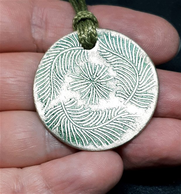 Pandantiv circular din fier galbui, decorat cu ramuri de pin pictate cu patina verde