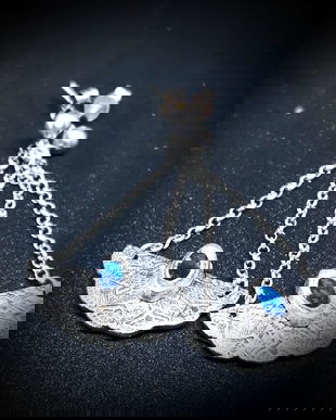 Cercei unicat, atarnatori, cu lant si pin, din argint 999, semicirculari, texturati pe o fata si impodobiti cu flori pe cealalta si cristale de spinel albastru