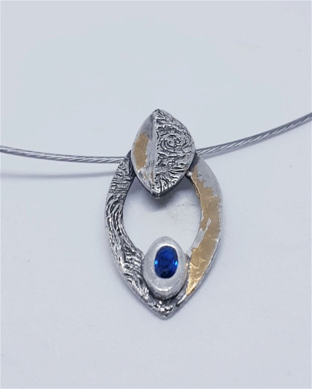 Pandantiv de autor, oval, din argint 999, partial texturat, partial decorat cu cu folie de aur si spinel albastru
