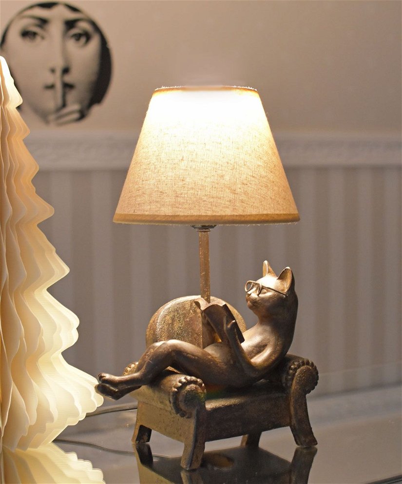 Lampa de masa cu o pisica citind pe un fotoliu