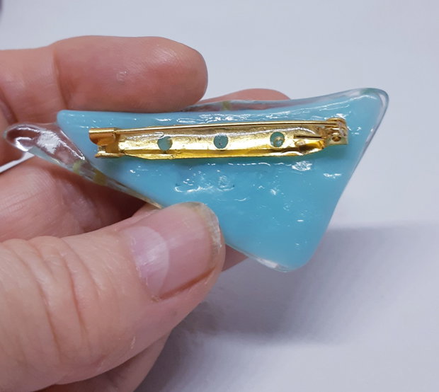 Brosa unicat, dreptunghiulara, din sticla fuzionata bleu si sticla dicroica, cu insertii delfini din argint pur si soare din foita de aur