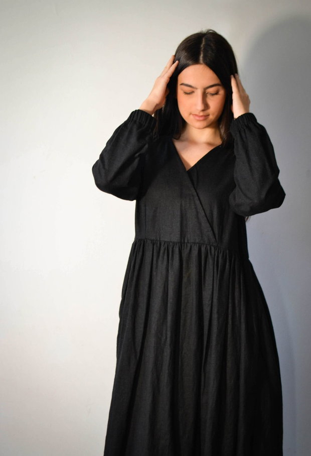 Rochie midi din in negru, petrecută în partea de sus.