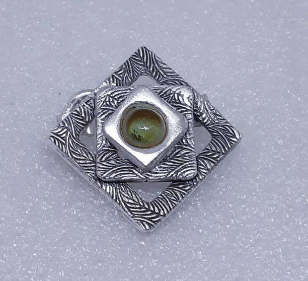 Broșă unicat din argint pur, cu design geometric compus din patrate suprapuse si un cabochon de sticla oliv