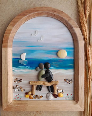 Tablou Pebble Art  Cuplu pe băncuță, privind marea, bărcile și soarele, decor romantic pe lemn