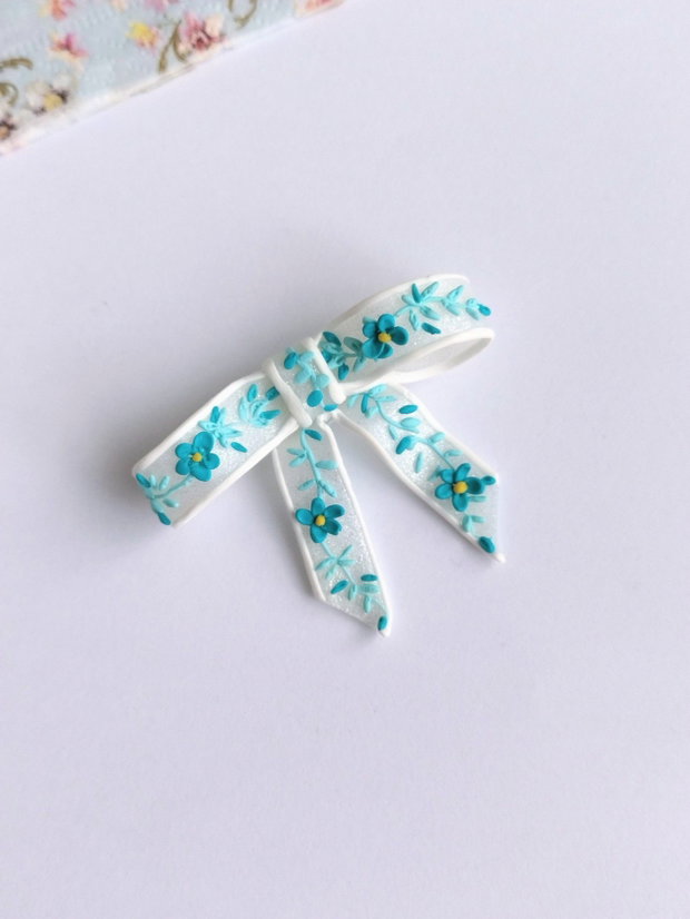 Broșă fundiță handmade Fimo alb translucid cu broderie turqois, design delicat