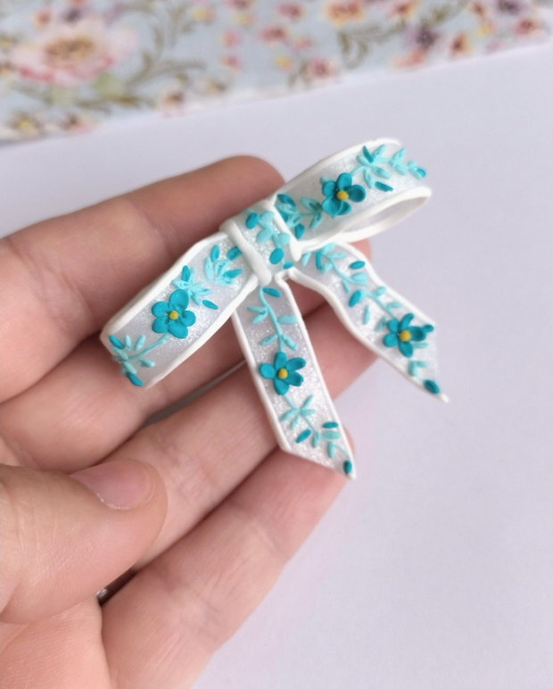 Broșă fundiță handmade Fimo alb translucid cu broderie turqois, design delicat
