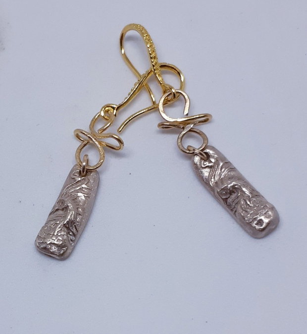 Cercei unicat din bronz, in forma de bagheta, cu un cap de phoenix cu ochi de zirconiu galben