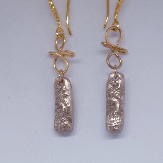Cercei unicat din bronz, in forma de bagheta, cu un cap de phoenix cu ochi de zirconiu galben