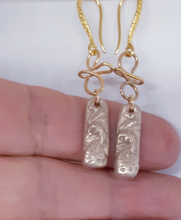 Cercei unicat din bronz, in forma de bagheta, cu un cap de phoenix cu ochi de zirconiu galben