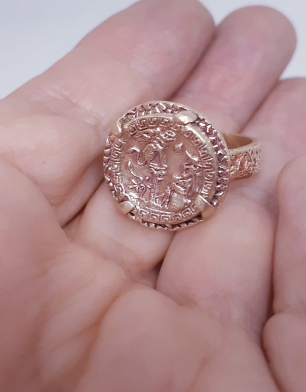 Inel unicat, din bronz, inspirat din mitologia si estetica Greciei antice, cu moneda centrala reprezentand legenda confruntarii dintre Oedip si sfinx si cu banda decorata cu un meandru