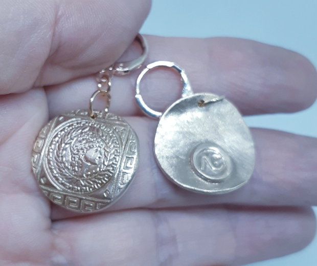 Cercei unicat, din bronz, tip moneda, asimetrici, inspirati din mitologia Greciei Antice, cu efigii ale zeitei Atena, in chenare cu motive traditionale