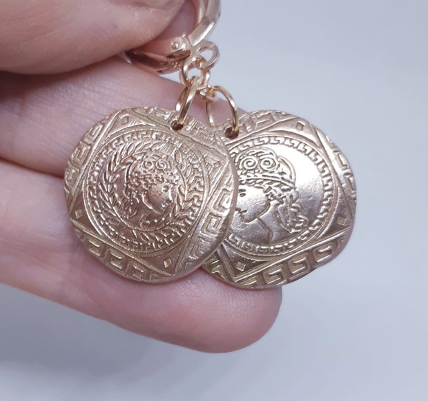Cercei unicat, din bronz, tip moneda, asimetrici, inspirati din mitologia Greciei Antice, cu efigii ale zeitei Atena, in chenare cu motive traditionale