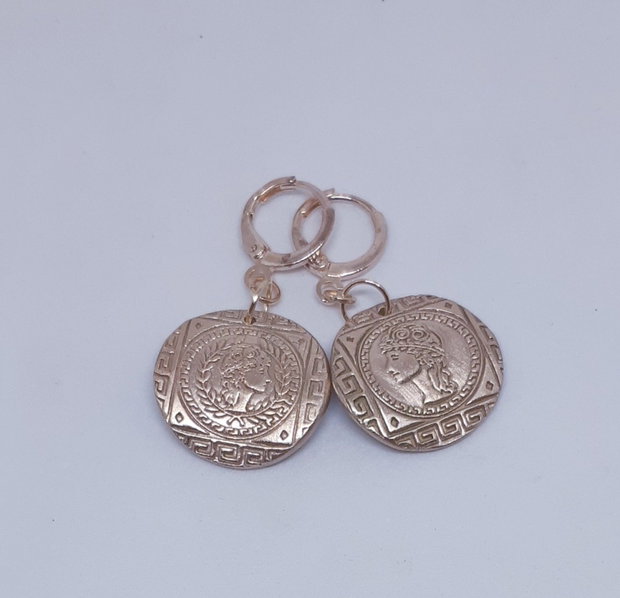 Cercei unicat, din bronz, tip moneda, asimetrici, inspirati din mitologia Greciei Antice, cu efigii ale zeitei Atena, in chenare cu motive traditionale