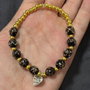 Brățară handmade cu mărgele din sticlă negre și aurii  charm inimă