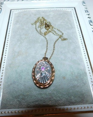 Colier caseta  pentru poze ,reprezentind  un inger cu aripile deschise , lantisor  atasat, aliaj placat cu aur, 11,25 grame ,rubin birmanez  central de 0.15 carate ,