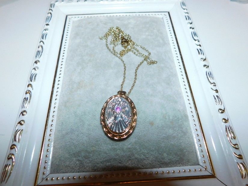 Colier caseta pentru poze ,reprezentind un inger cu aripile deschise , lantisor atasat, aliaj placat cu aur, 11,25 grame ,rubin birmanez central de 0.15 carate ,